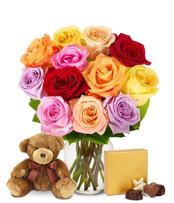 Heartfelt apology gift set with one dozen rainbow roses, a cuddly teddy bear, a box of chocolates, an optional glass vase, and a personalized message.