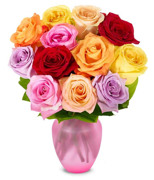 A bouquet of multicolored roses in a clear vase, featuring red, pink, orange, yellow, peach, and lavender blooms, arranged with green leaves for a vibrant and cheerful display.