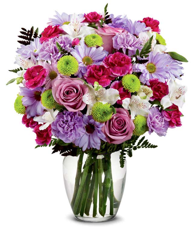 A bouquet featuring lavender daisies, lavender roses, hot pink mini carnations, lavender carnations, white alstroemeria, and green button poms, with an optional vase.