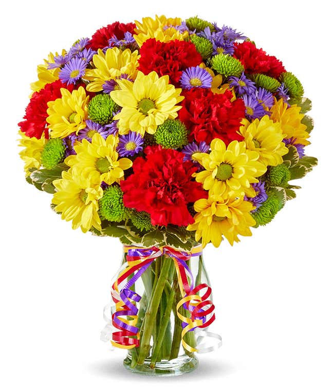 Yellow daisies, red carnations and green button pops in a glass vase