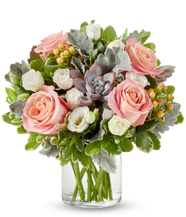 A charming floral arrangement featuring pink roses, white lisianthus, peach berries, a succulent cutting, all beautifully arranged in a glass vase, with an option for personalization. This vibrant mix creates a stunning and unique display.