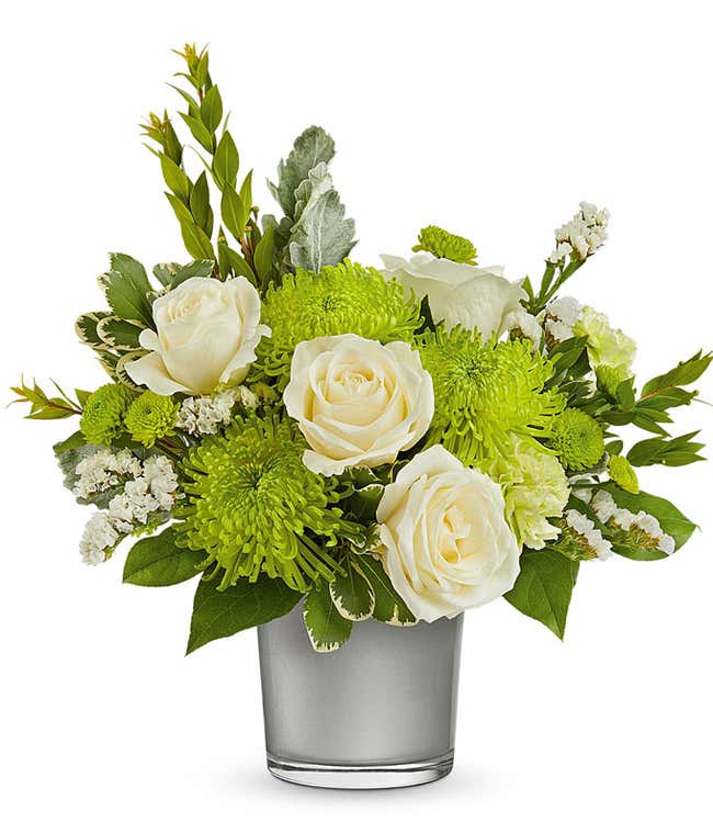  White Roses, Green Carnations, and Chrysanthemums in a Silver Glass Cylinder Vase, accented with Floral Greens.