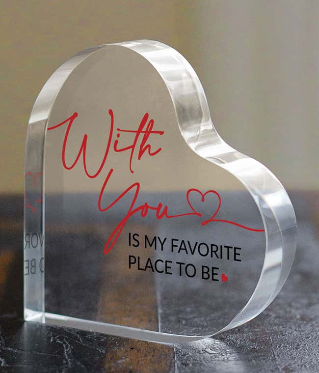 Acrylic heart with clear background. In red cursive font,