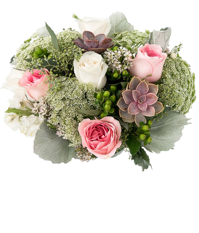 Partial image of A floral arrangement featuring white roses, pink roses, succulents, white stock, hypericum berries, Queen Anne's lace, white waxflower, and seeded eucalyptus, with an optional glass vase. without vase